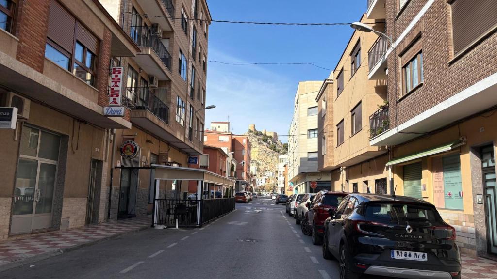 Una de las calles de la localidad con el castillo de fondo