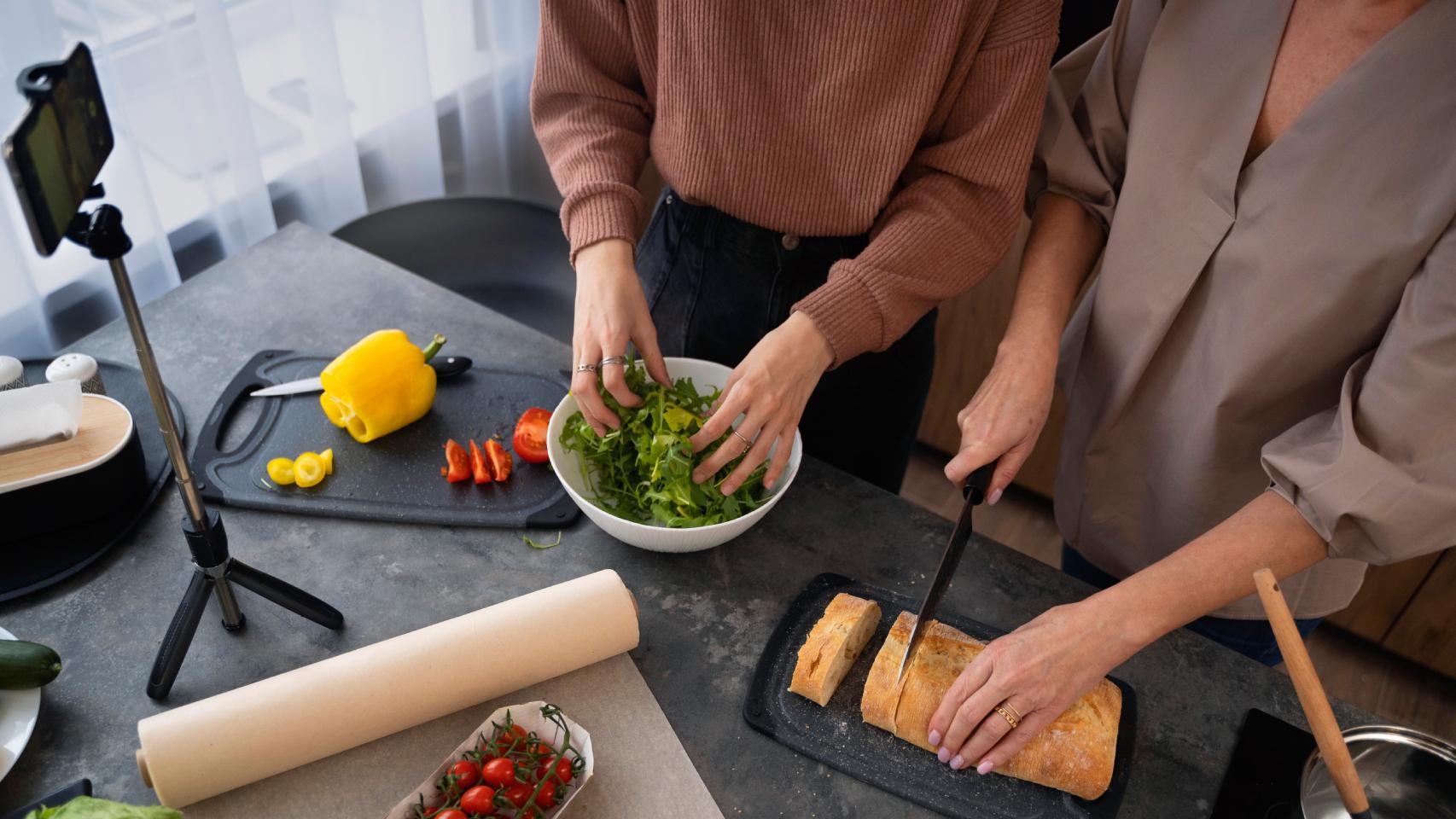 Dos mujeres grabando cómo cocinan juntas.