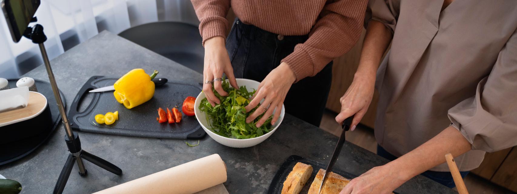 Dos mujeres grabando cómo cocinan juntas.