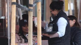 Una camarera atendiendo clientes en una terraza.