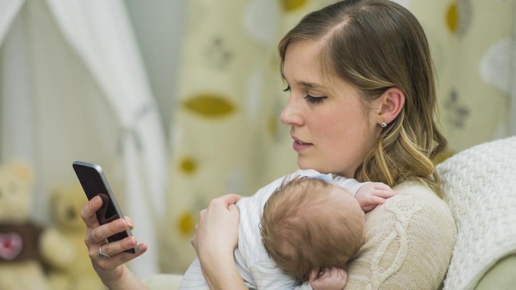 Imagen de archivo de una madre con su teléfono.