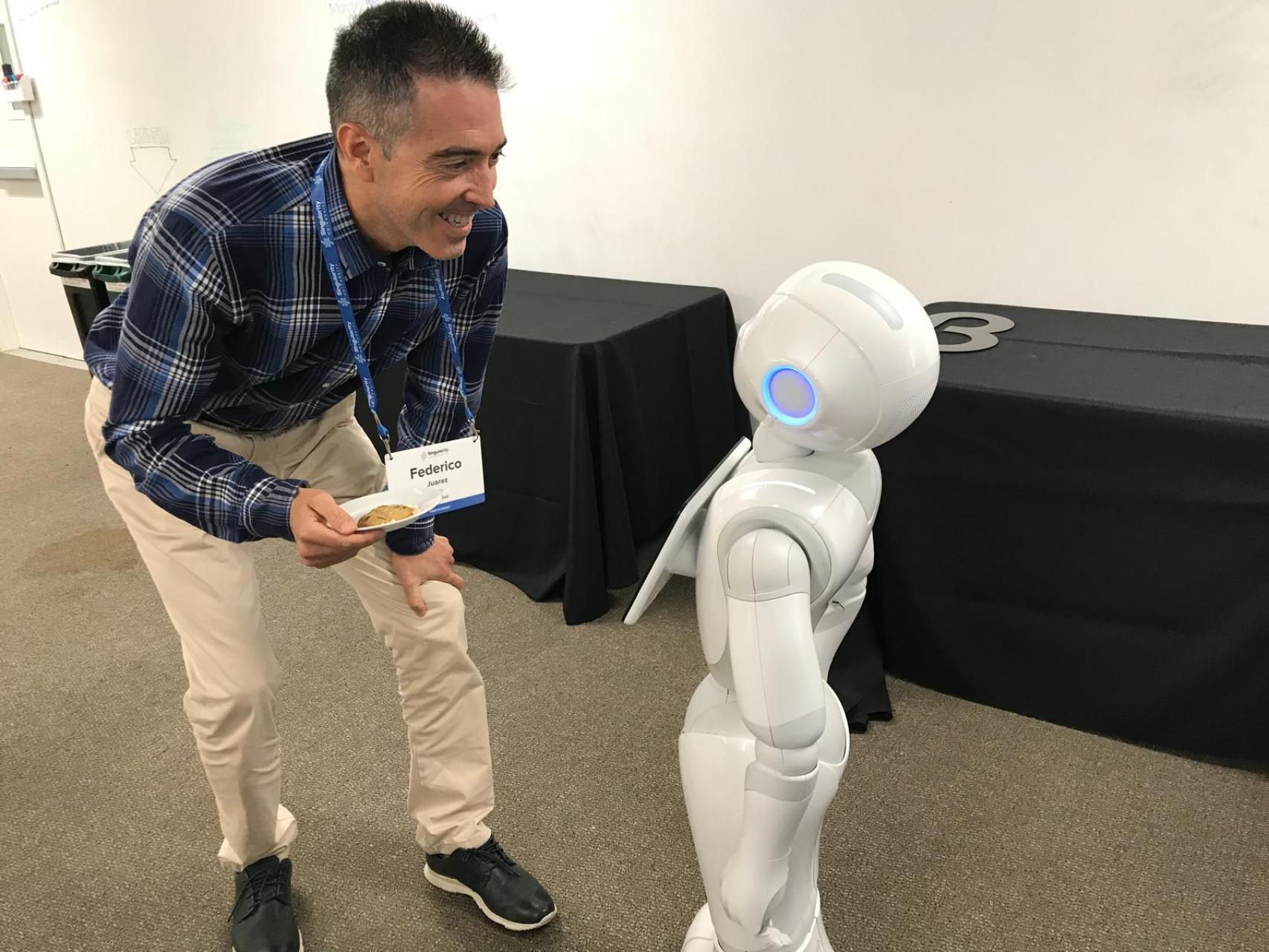 Federico Júarez, experto consultado en el estudio OBEDE, frente a un robot con forma humanoide