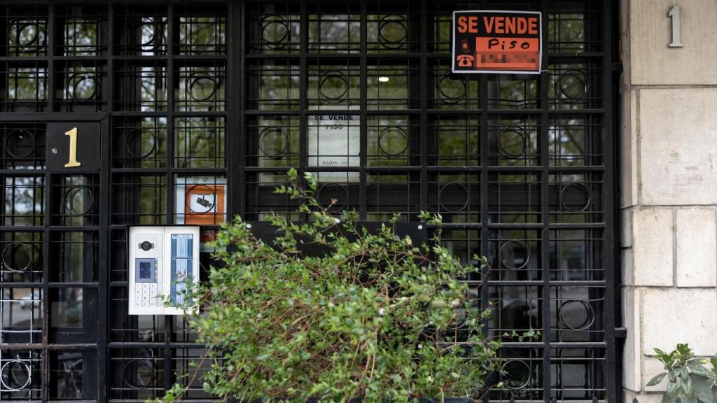 Vista de un cartel de 'Se vende' en un portal de un edificio.