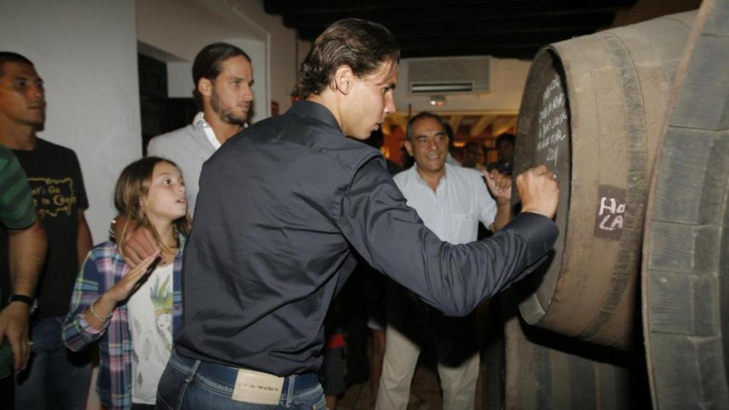 Rafa Nadal firmando en uno de los barriles de El Pimpi.