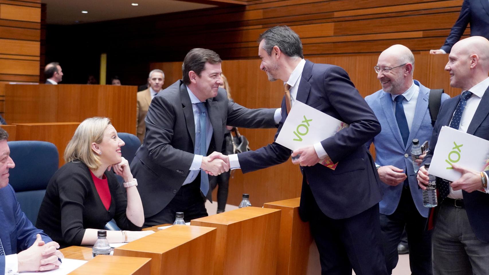 El presidente de la Junta de Castilla y León, Alfonso Fernández Mañueco, saluda al portavoz de Vox, David Hierro, en un pleno de las Cortes en febrero de 2025