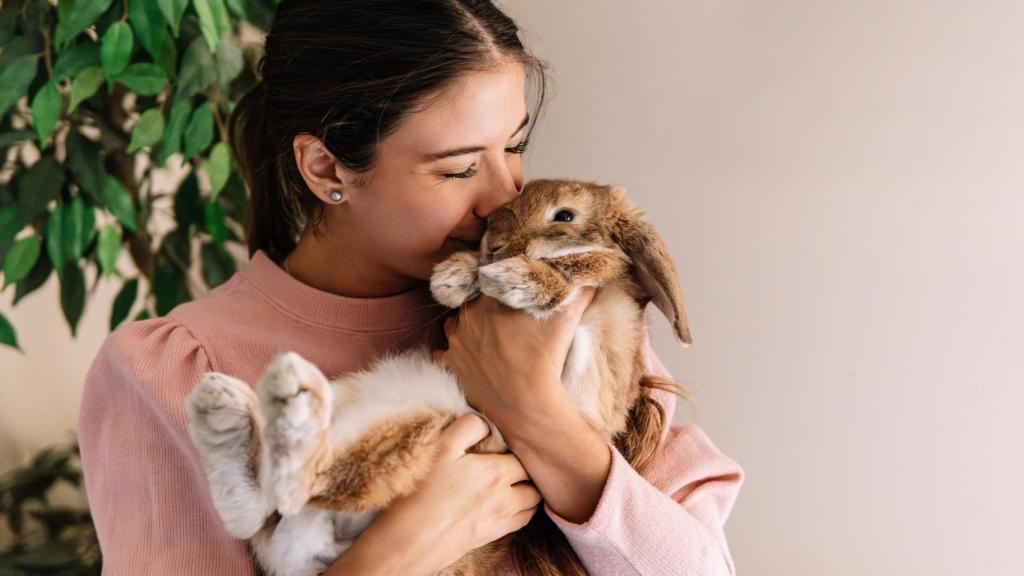 Una mujer sosteniendo a su conejo.