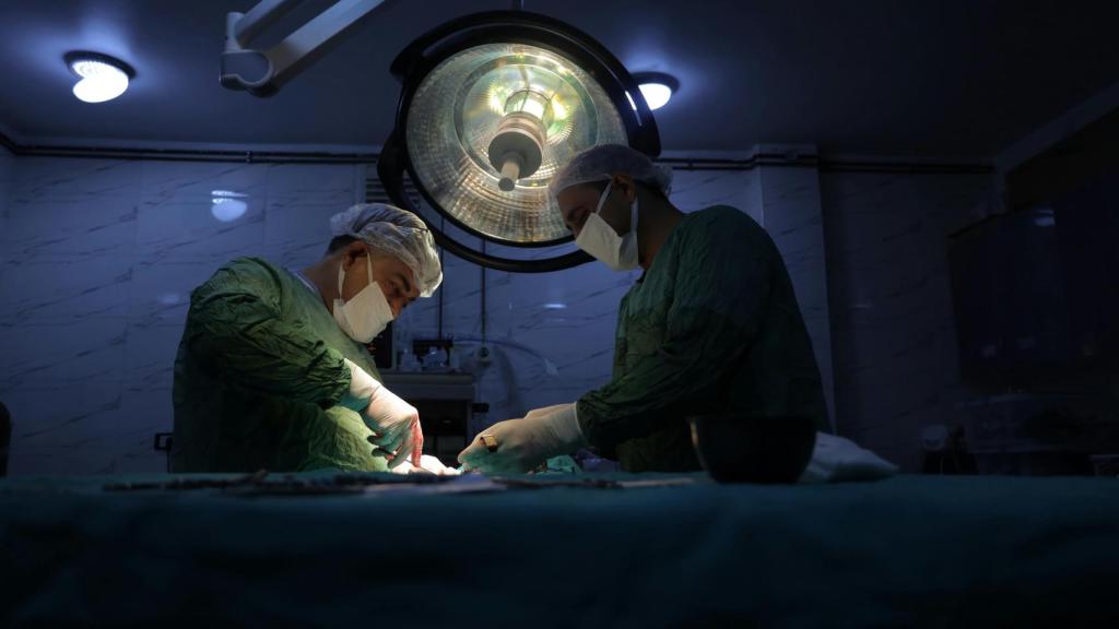 Dos cirujanos en medio de una intervención.