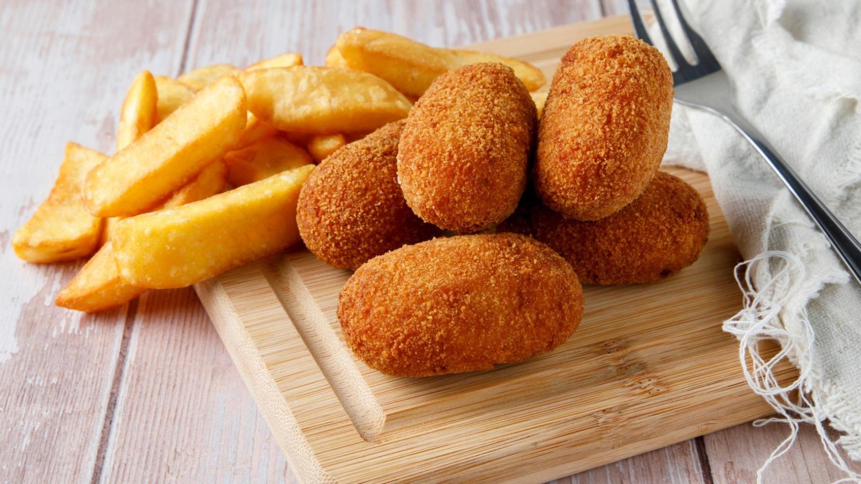 Un plato de croquetas con patatas fritas.