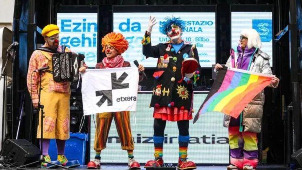 A la izquierda, los payasos Pirritx, Porrotx y Marimotots sostienen una bandera de Extxera, en castellano a casa, en alusión a la excarcelación de los etarra; a la izquierda, la drag queen Yogurinha Borova.