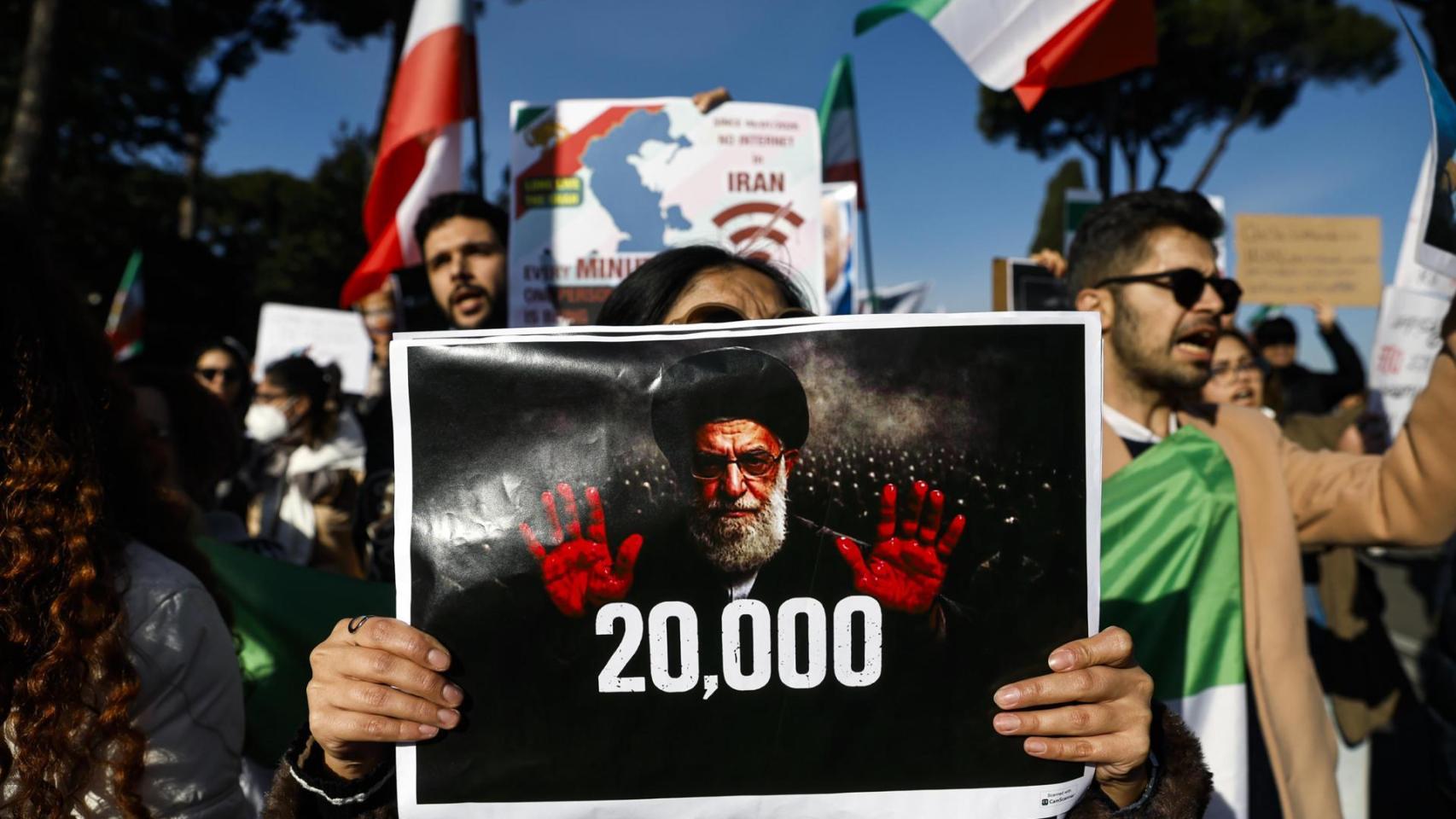 Una mujer sujetando un cartel de Jamenei durante una de las manifestaciones en apoyo al pueblo iraní en Roma.
