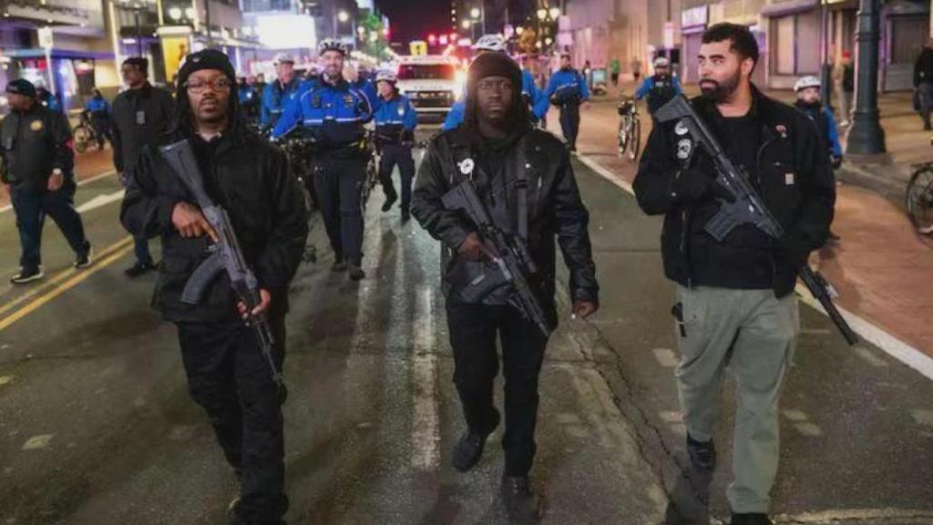 Varios miembros de los Panteras Negras caminan armados. A la derecha, su líder, Paul Birdsong.