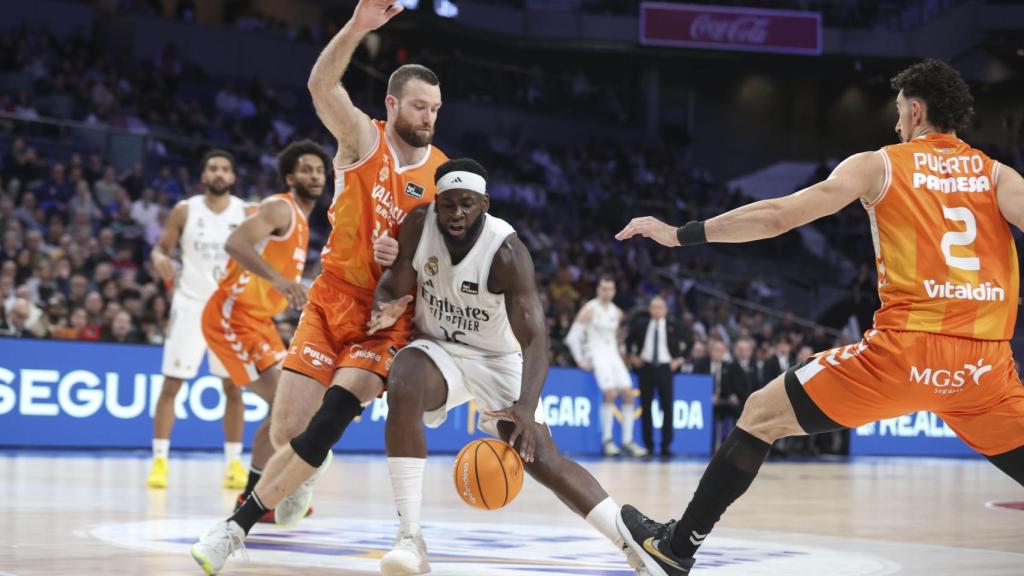 Garuba, conduce el balón presionado por dos jugadores del Valencia Basket.