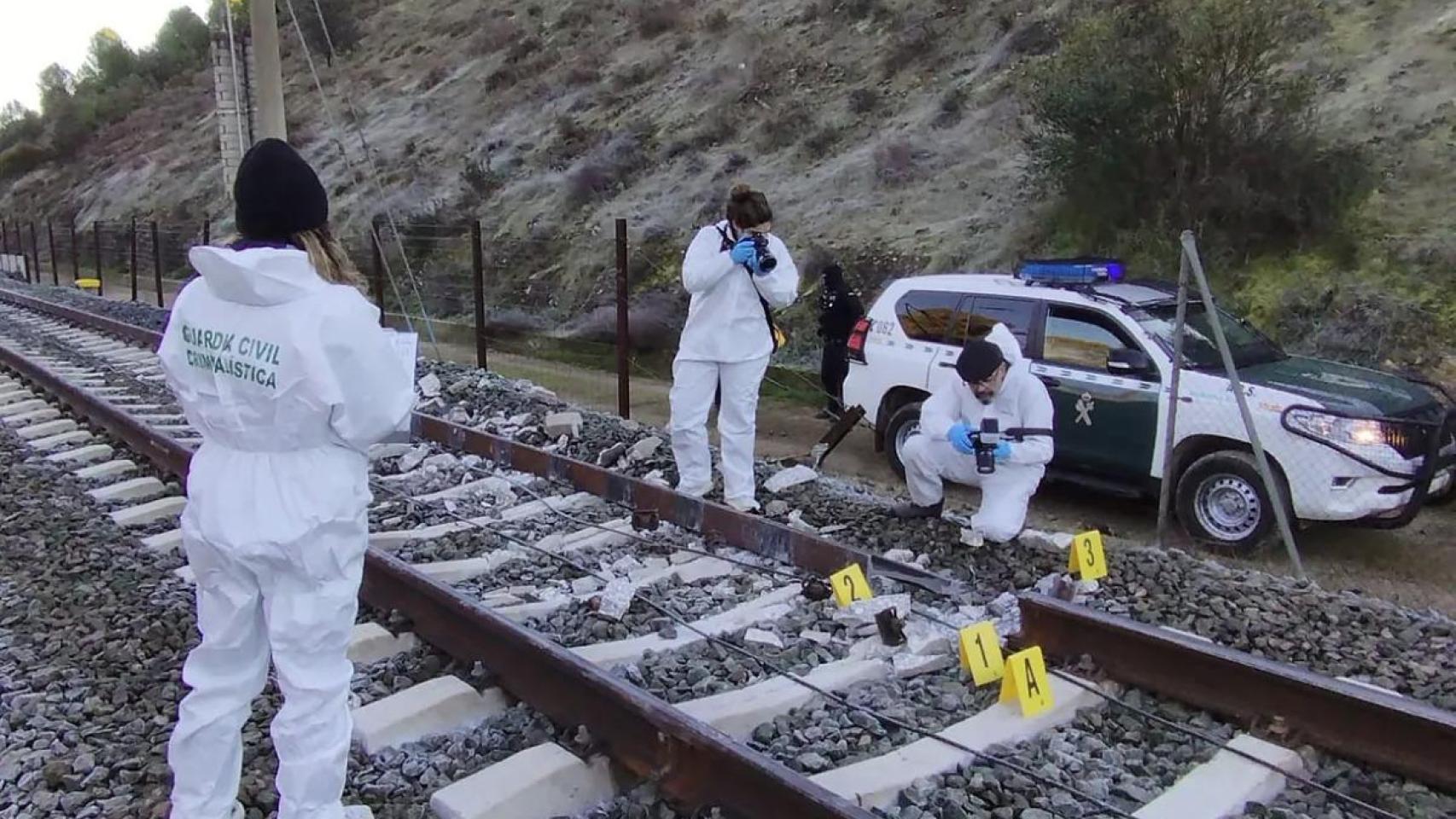 Investigadores de la Guardia Civil analizan la vía por la que circulaba el tren Iryo siniestrado este domingo.