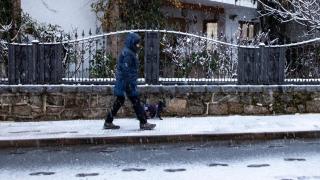 Um homem caminha pela cidade nas montanhas de Madrid sob a neve.