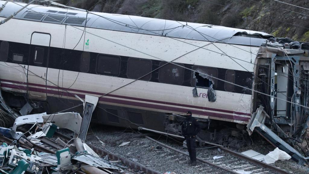 Un agente de la Guardia Civil, junto a uno de los trenes siniestrados tras el choque mortal de dos convoyes de alta velocidad en Adamuz (Córdoba), el 19 de enero de 2026.