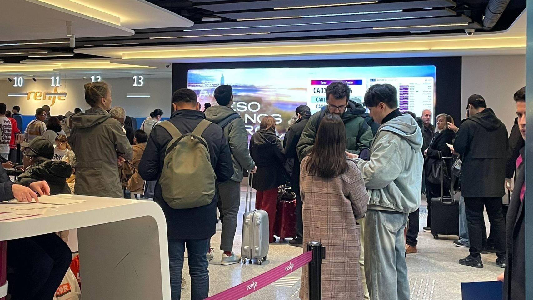 Pasajeros en el punto de información de Renfe en la estación de Atocha en Madrid este lunes tras el accidente de tren en Córdoba.