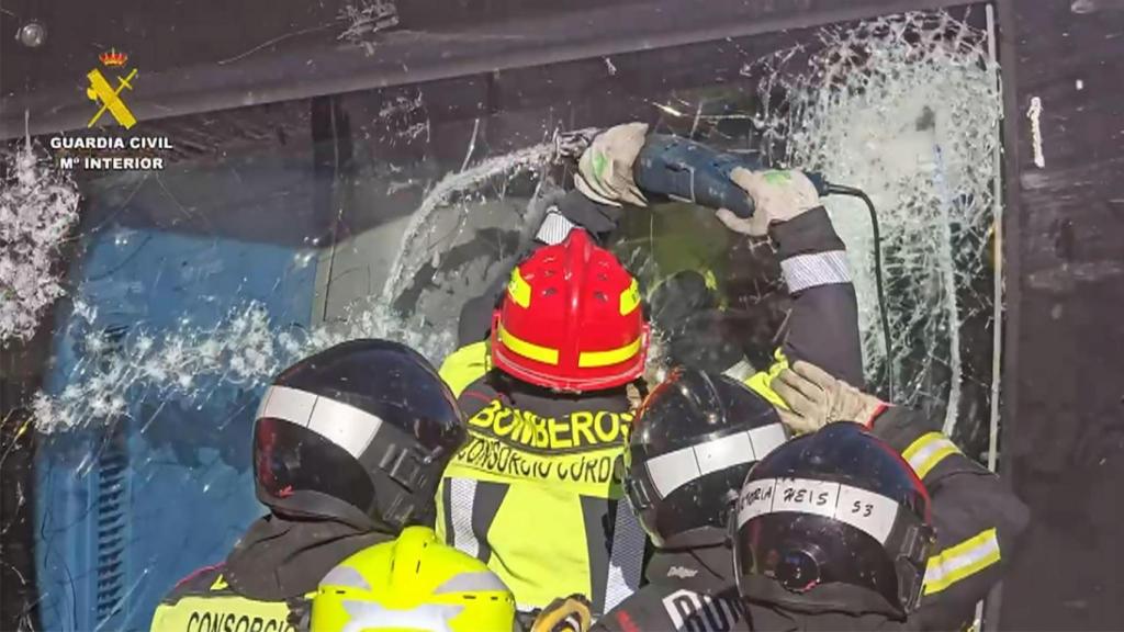 Los bomberos intentan acceder a uno de los vagones en las labores de rescate.