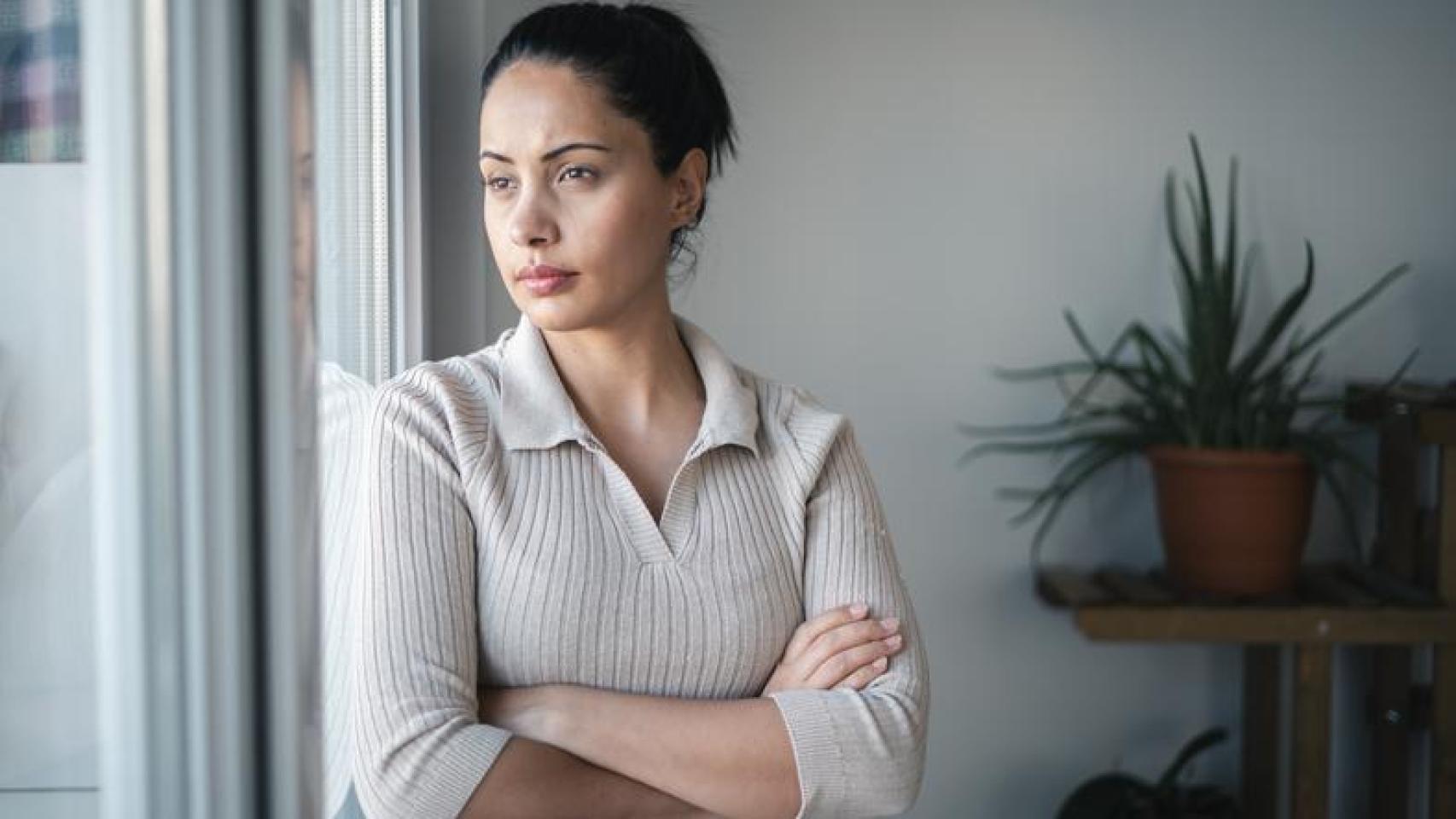 Mujer mirando por la ventana.