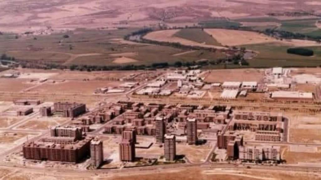Foto aérea del barrio del Polígono de los años 80 con los primeros bloques de la zona residencial y el Polígono industrial al fondo.