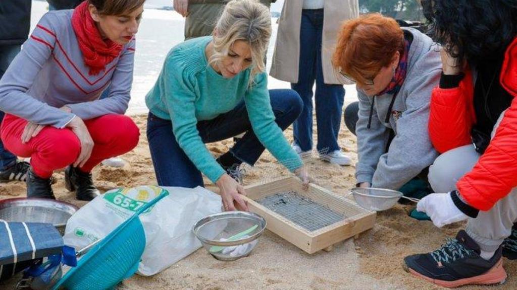 Yolanda Díaz recoge 'pellets' en 2024 en una playa de Galicia.