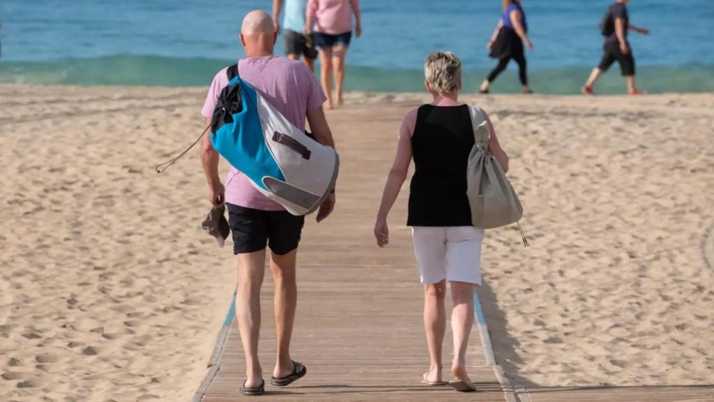 Turistas disfrutan del sol en la playa de Morro Jable, en Fuerteventura.