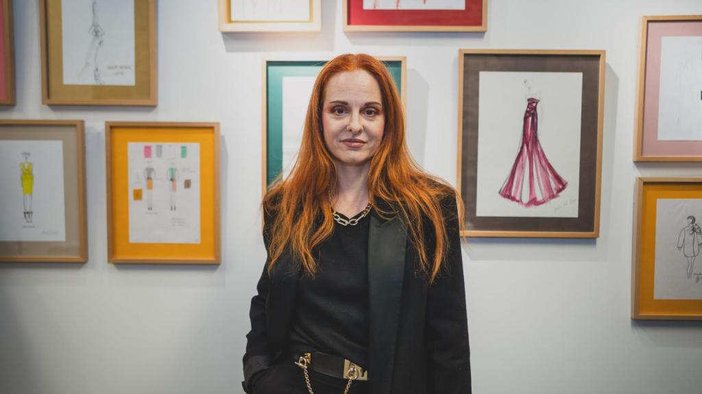 Ana Locking posa con bocetos de los diseñadores de ACME al fondo.