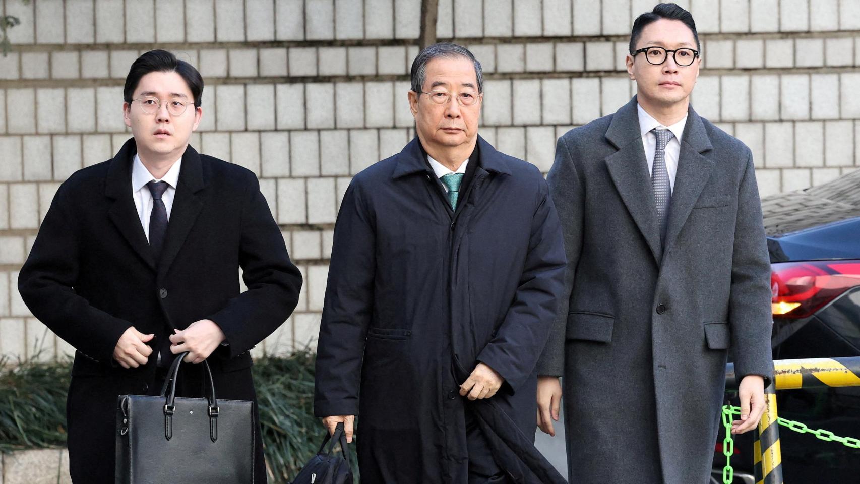 El exprimer ministro surcoreano Han Duck-soo, en el centro, a su llegada al tribunal de Seúl este miércoles para escuchar la sentencia.