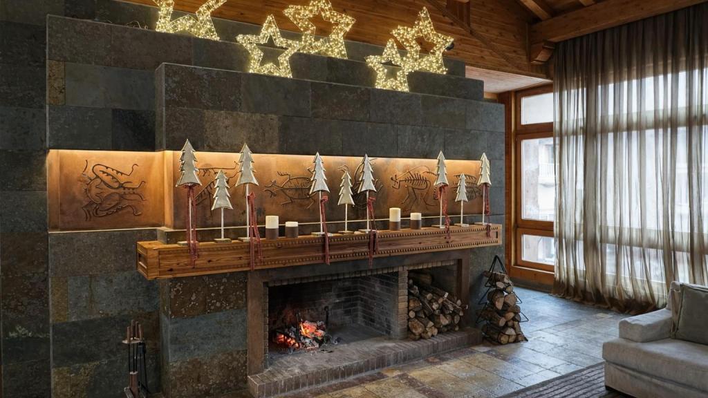 Salones de lectura con chimenea encendida y ventanales del Sport Hotel Hermitage & Spa.