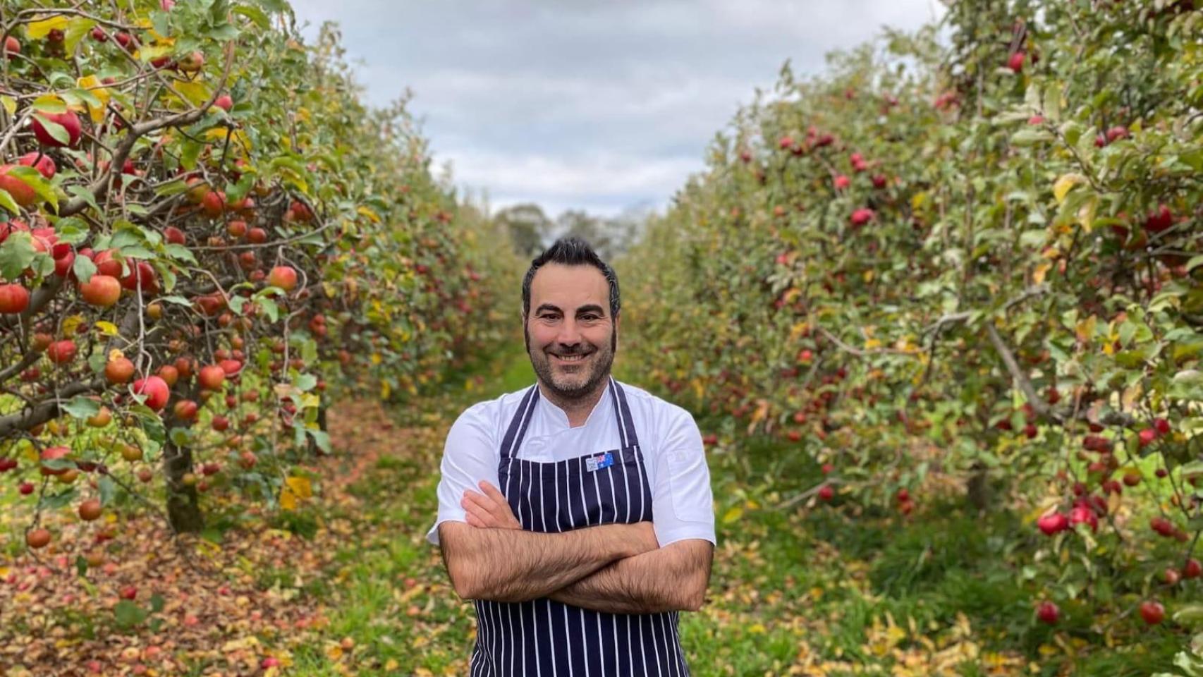 Rubén López Mesa, cocinero en Australia, junto a una plantación de manzanas