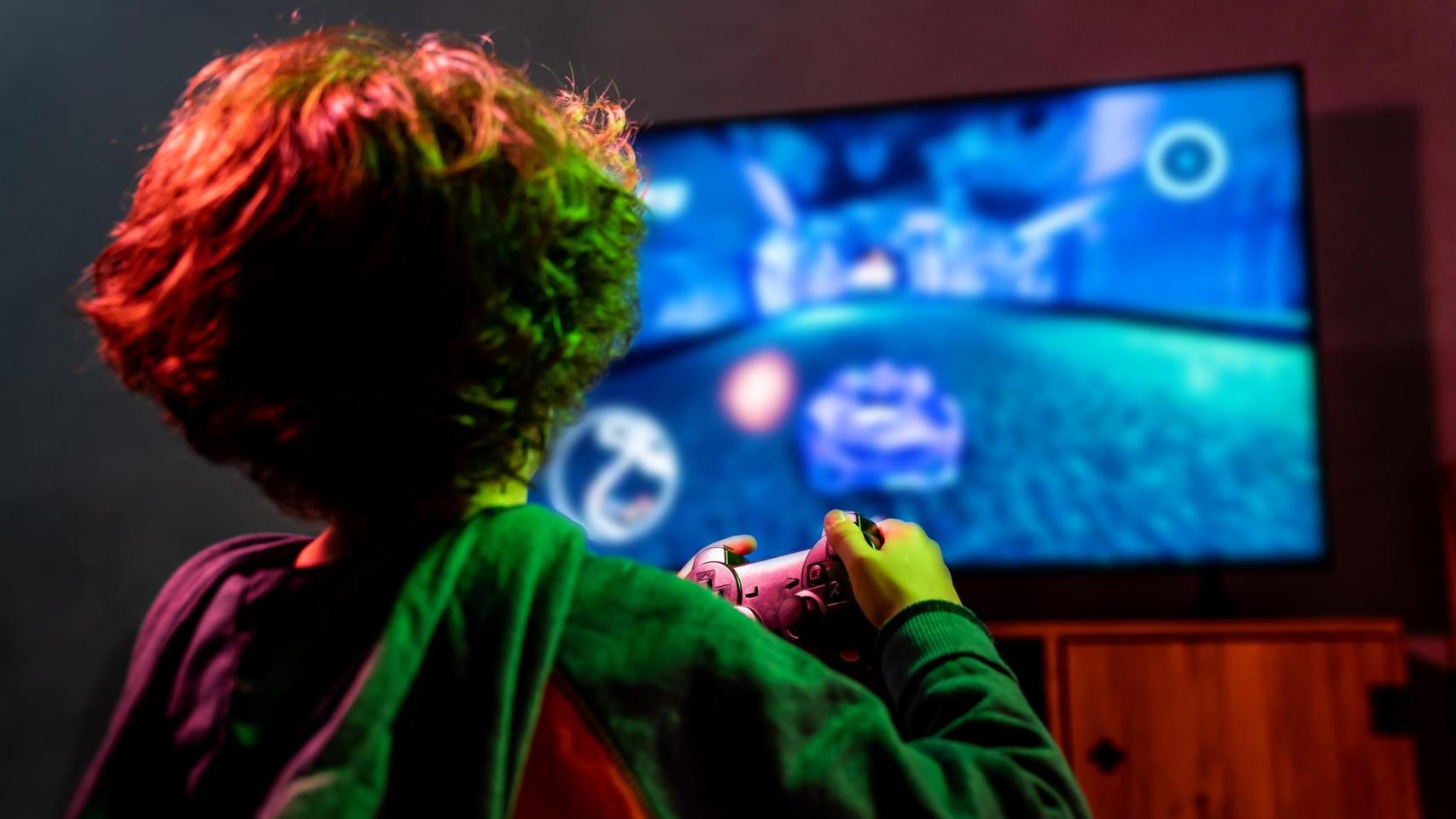 Niño de espaldas jugando a un videojuego.
