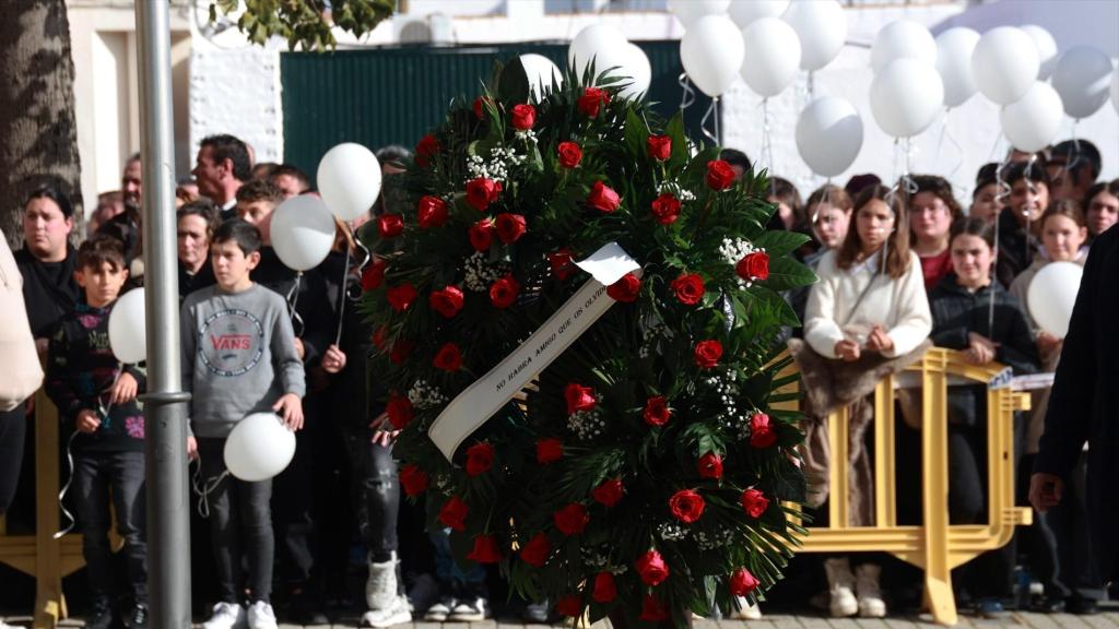 Niños portan globos blancos en la despedida de la familia Zamorado fallecida en el accidente de Adamuz.