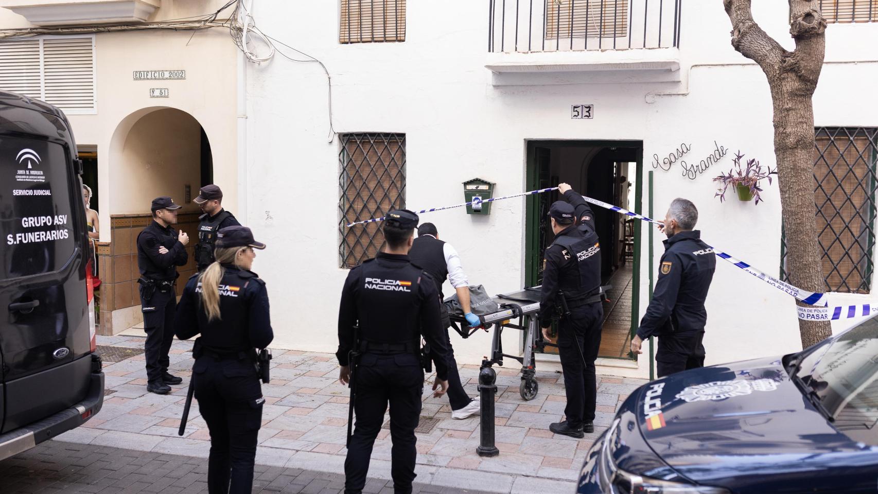 La Policía Nacional y trabajadores de los servicios funerarios trasladan el cuerpo de uno de los fallecidos.