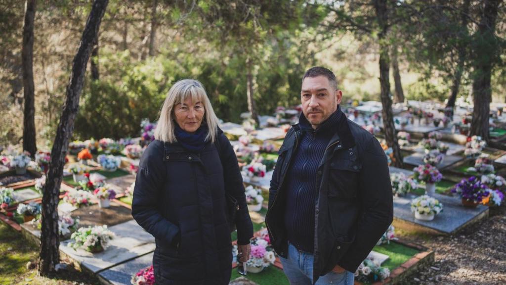 Juana y Fernando, los 'guardas' del cementerio, en la parte decorada con flores que cada domingo pone una de las mujeres que va a visitar la fosa de sus perritos.