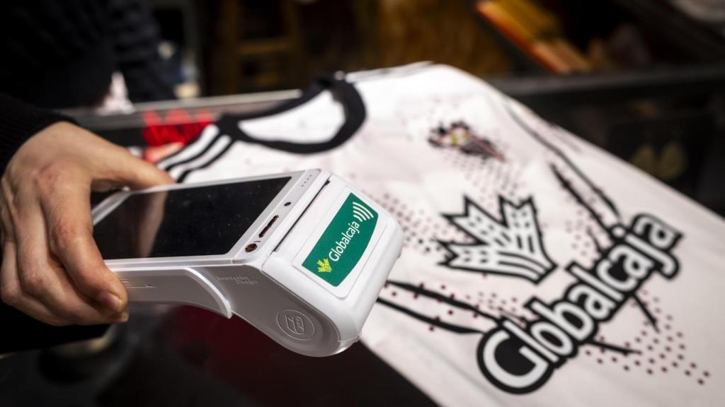 Un TPV de Globalcaja junto a una camiseta del Albacete Balompié.