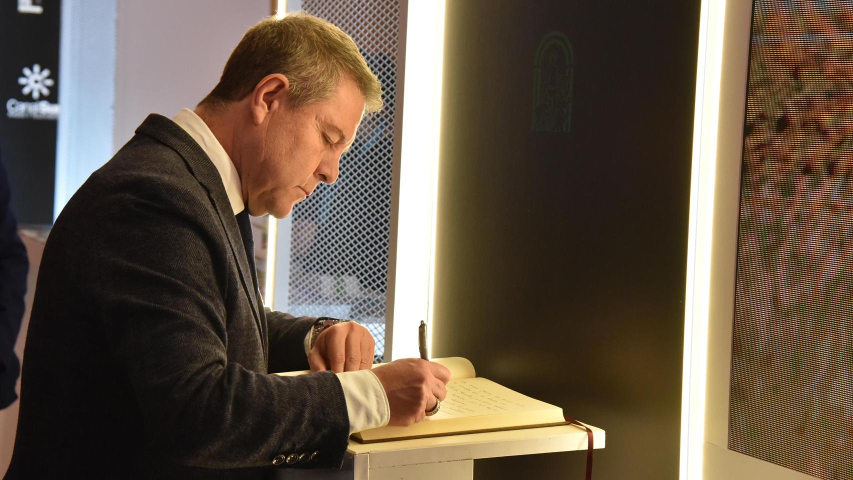 Emiliano García-Page firmando en el libro de condolencias disponible en el estand de Andalucía en Fitur 2026 tras el accidente de tren de Adamuz (Córdoba).