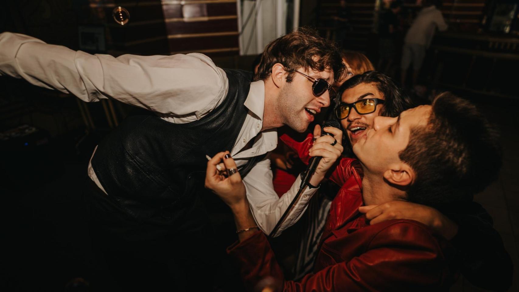Varias personas cantan en un karaoke.