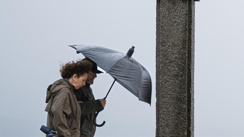 Dos personas se refugian de la lluvia con paraguas