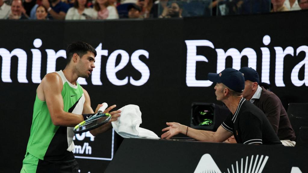 Carlos Alcaraz hablando con Samuel López, su entrenador, durante un partido del Open de Australia 2026