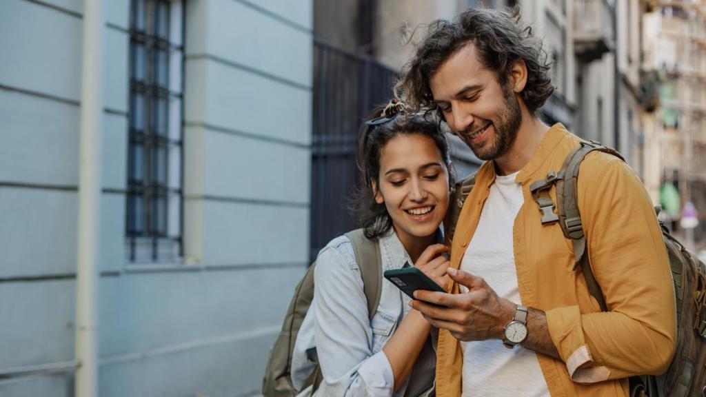 Imagen de archivo de una pareja viendo fotos en un teléfono móvil.