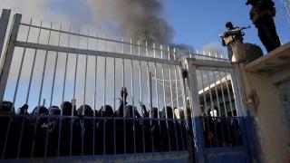 Miembros de las fuerzas de seguridad del Gobierno sirio montan guardia mientras un grupo de detenidas se reúne en el campamento de al-Hol.