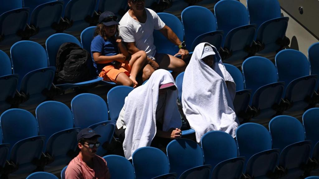 Aficionados en el Open de Australia 2026 protegiéndose del calor extremo