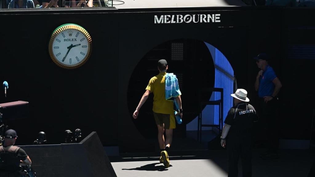 Jannik Sinner abandonando la pista tras pararse su partido en Australia por el calor extremo