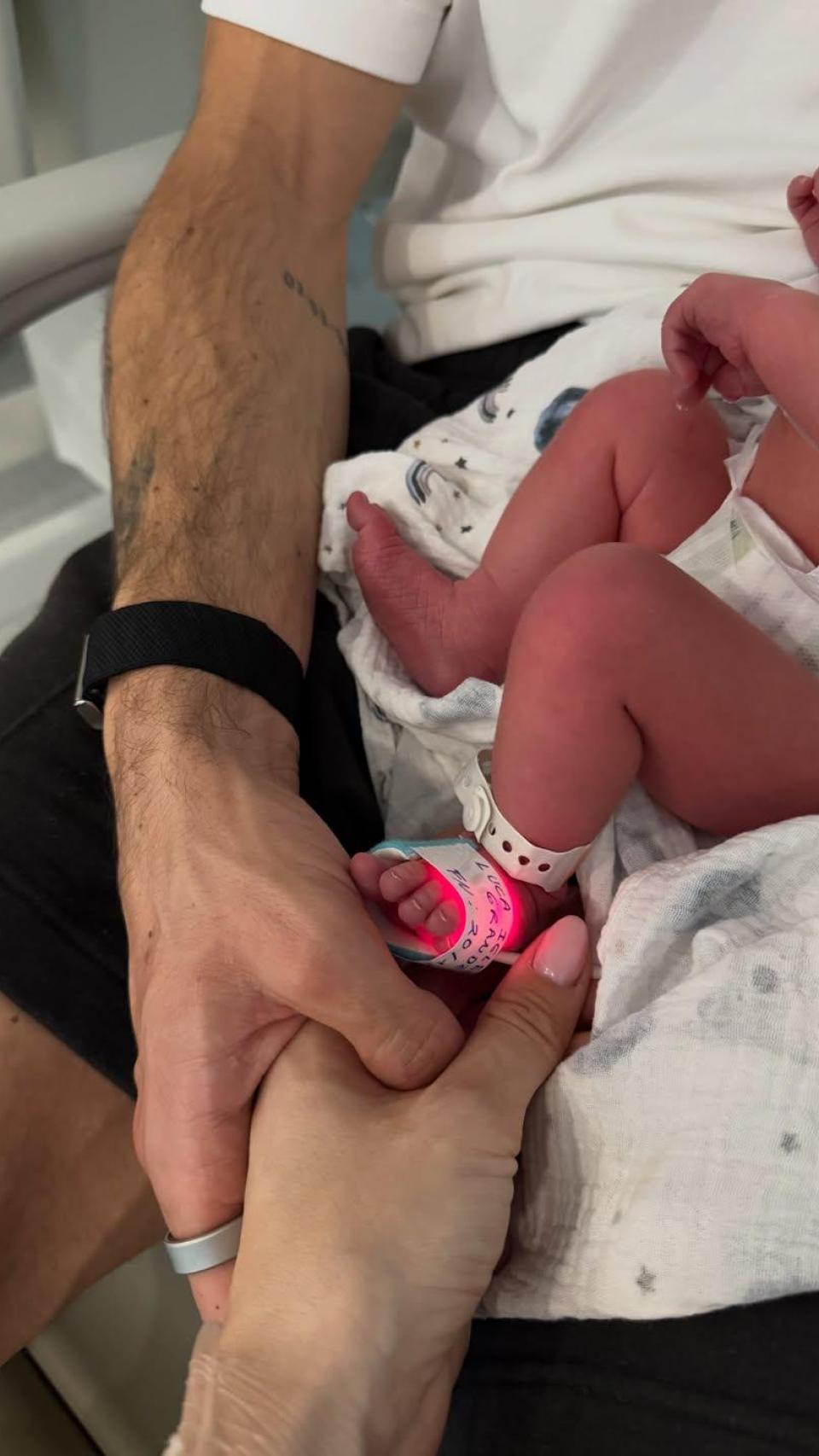 Juan Iglesias, pareja de Estela Grande, con uno de sus mellizos recién nacidos.