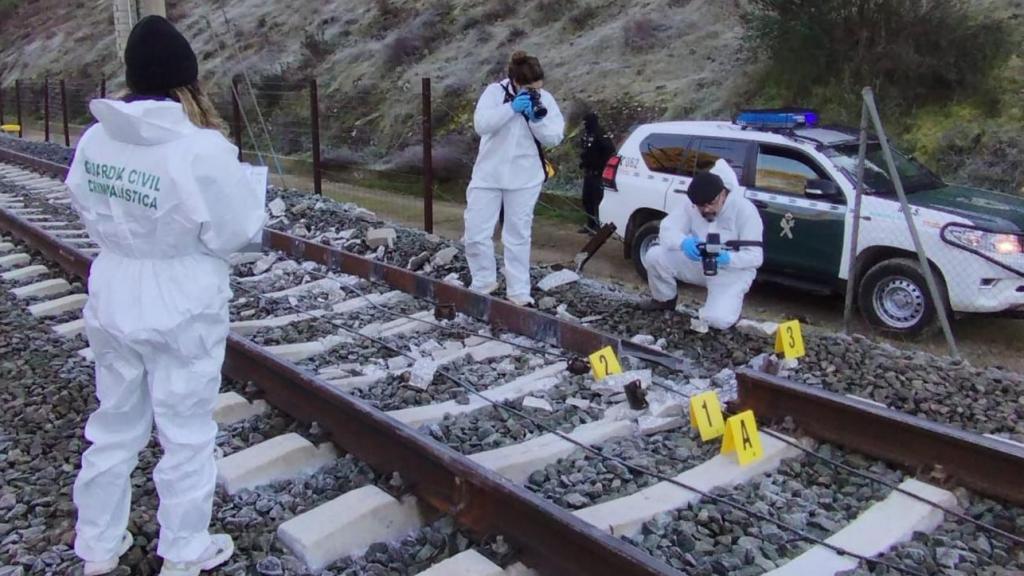 Los investigadores de la Guardia Civil fotografían el raíl roto que procovó el accidente de Adamuz (Córdoba).