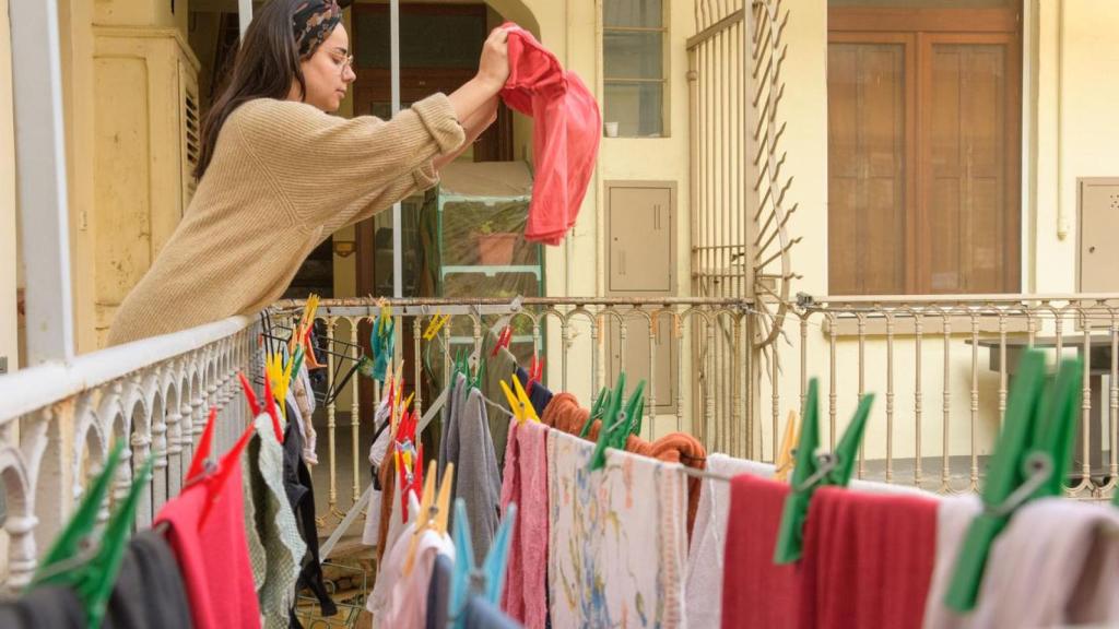 Una mujer secando la ropa.