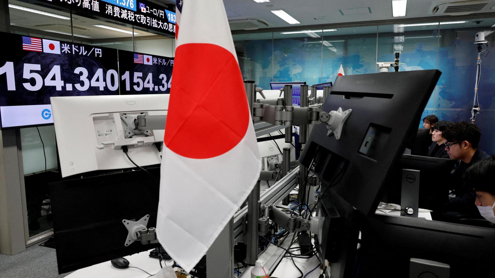 Empleados de Gaitame.com trabajan frente a monitores que muestran el tipo de cambio actual del yen.