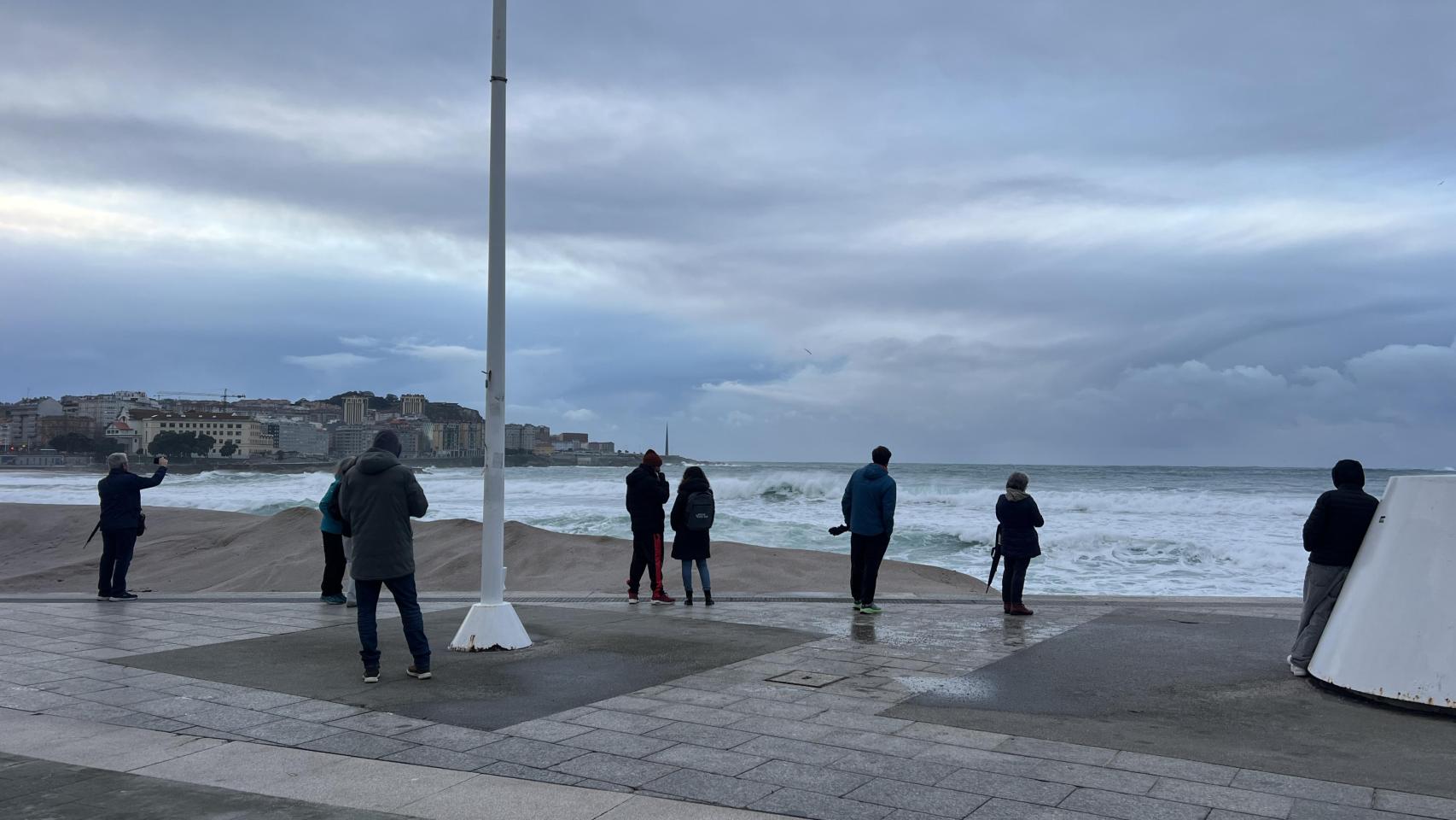 Imagen de varios curiosos el viernes con la duna de fondo.