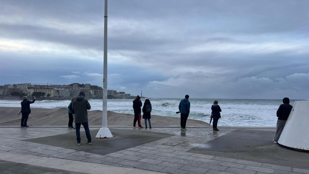 Imagen de varios curiosos el viernes con la duna de fondo.