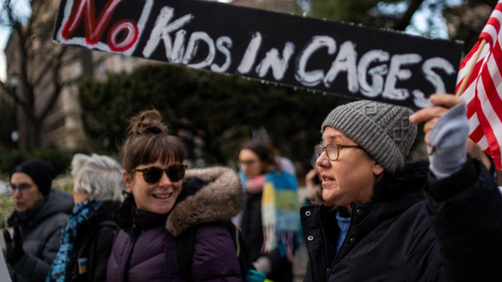 Manifestantes con una pancarta en la que se lee el lema 'Que no haya niños en jaulas'.
