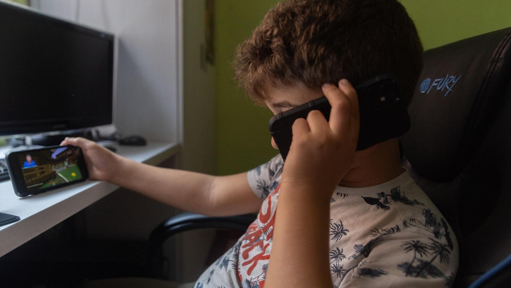 Un niño utilizando su teléfono móvil.